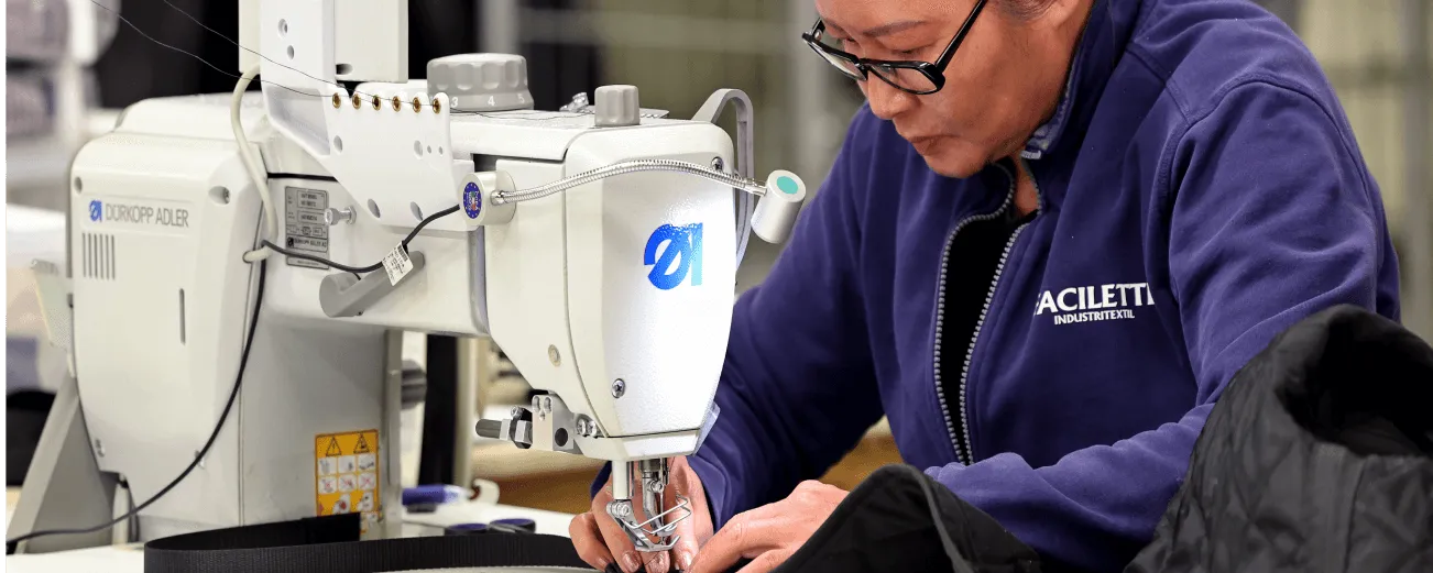 Sömnad vid industrisymaskin i fabriken i Lidköping